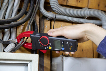 An electrician is installing wires on an electric meter