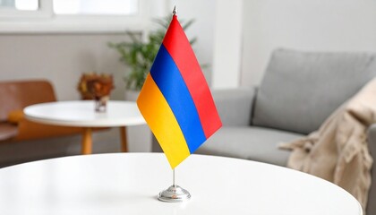 A small tabletop Armenian flag stands upright on a silver base
