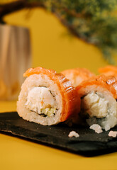Sushi rolls with salmon and cream cheese on a black slate plate
