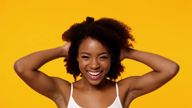 Woman with curly hair laughing and shaking her hair in slow motion.