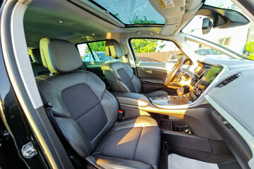 Interior view of a modern SUV showcasing spacious design and luxury features, highlighting comfort and technology on a sunny day in a suburban area
