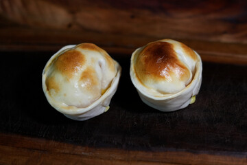 Empanadas redondas al horno sobre bandeja de madera