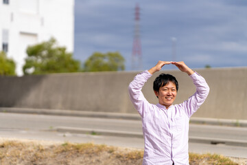 手で丸印を作って「OK」を示す笑顔の男性｜ビジネス承認