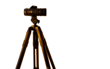 Tripod silhouette captured against the warm glow of golden hour light creating a serene outdoor scene isolated on transparent background PNG