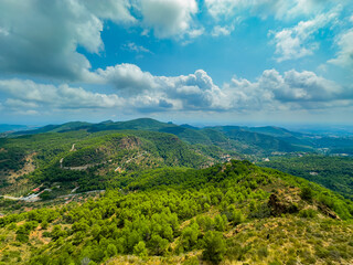 Fototapeta premium Vibrant green hills stretching beneath cloud-covered skies in a serene mountain landscape captured during midday