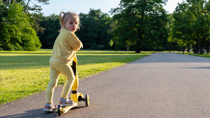 Scooter and kid. Toddler outdoor riding. Fun yellow play childhood freedom.