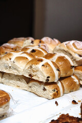 Freshly baked hot cross buns with icing and raisins on display at a local bakery in Cardiff