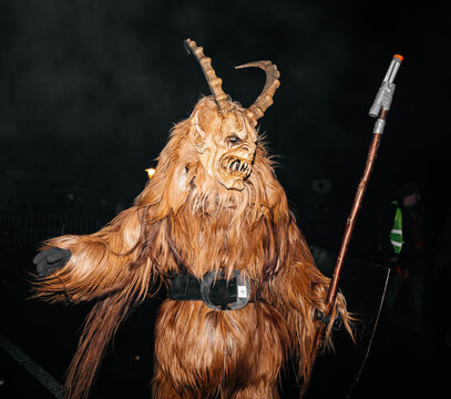 Krampuslauf Noetsch festival features a costumed figure of Krampus, showcasing intricate details of the traditional folklore character in a lively night atmosphere
