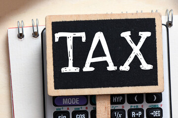 TAX word on a black small chalk board.