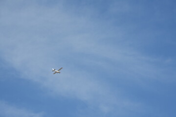 white plane flying against the blue sky background.