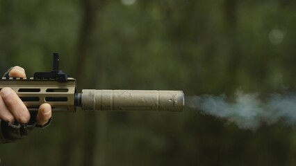 Soldier with AR15 carbine on a mission. Close-up rifle with a collimator shooting a bullet