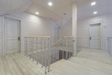 Bright and airy staircase area featuring modern design elements. The space has wooden flooring and a stylish railing, creating an inviting atmosphere in a contemporary home.