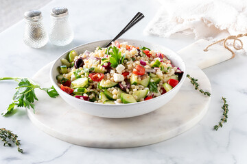 A bowl of Israeli Mediterranean couscous salad, ready for eating.