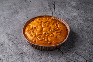 Caramel Almond Tart in a Rustic Paper Cup on a Textured Stone Background