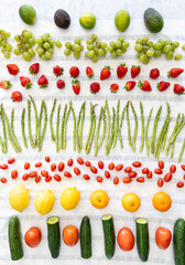 Rows of freshly vinegar washed fruits and vegetables drying on a towel.