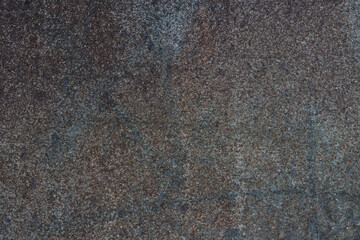 Dark abstract grunge background of a corroded rusty metal texture. Close-up of an old, weathered, and distressed steel surface.
