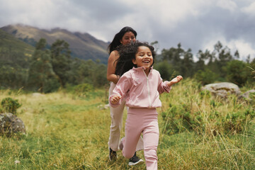 Mother and daughter playing outdoors enjoying nature. Children's Week