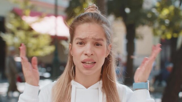Shocked upset woman reacting to unpleasant awful idea, dissatisfied with bad quality shake head No, dismiss proposition, don't like proposal outdoors. Closeup Caucasian girl tourist on city street.