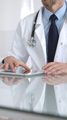 Doctor using tablet computer, providing healthcare consultation, digital medical technology, professional man in lab coat. Medicine and health care