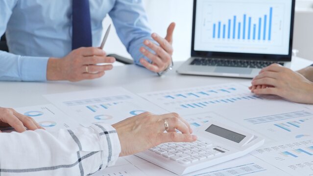 Accouters analyzing financial data using charts, graphs, and reports during an office meeting, collaborating on strategy. Business people concept - Powered by Adobe