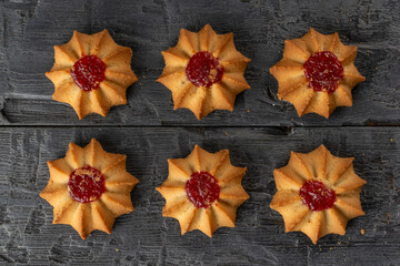 Jam-Centered Star-Shaped Cookies on Rustic Wooden Background for Cozy Culinary Inspiration