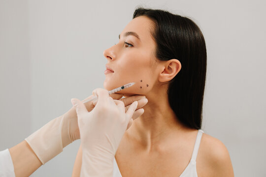 Bruxism injecting for teeth grinding by a cosmetologist. Bruxism injection facial for a treatment with botulinum toxin in an aesthetic medicine clinic.