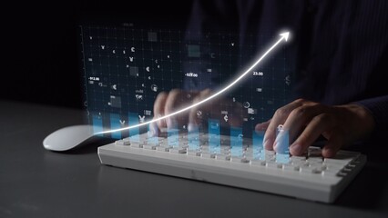 A person uses a white keyboard while digital graphs and arrows emerge, symbolizing innovation and growth in technology and business analytics in a modern workspace. Copula