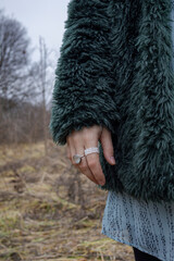 Woman’s hand with rings over autumn field, Dubrovitsky Forest, November