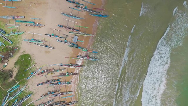 Teamwork as Fishermen Push Vibrant Traditional Boat into Bright Blue Sea