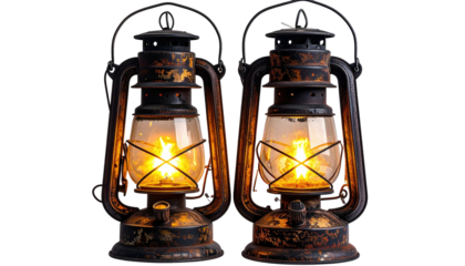 Two antique kerosene lamps burning, vintage style, black with golden rust details against black backdrop