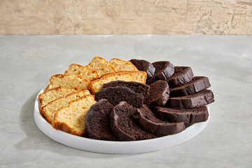 Sliced vanilla and chocolate pound cakes arranged on round white platter.