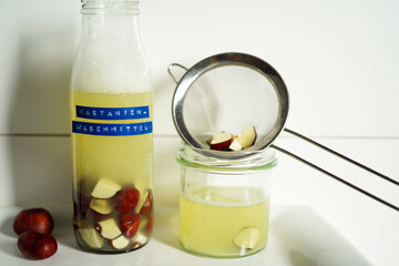 Natural detergent prepared from horse chestnuts in a clear glass bottle with light brown liquid. German text on the label indicates natural, eco-conscious living.