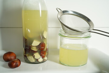 A glass bottle filled with homemade liquid detergent made from horse chestnuts and water. Eco-friendly, biodegradable, and zero waste cleaning product.