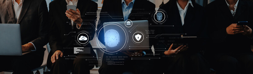 A group of business professionals engaged with various digital devices showcases the intersection...