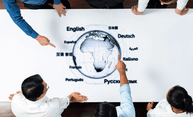A diverse group of professionals engages with an interactive world map, highlighting various languages, fostering collaboration and global communication in a modern office environment. Trope