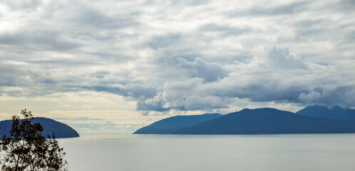 Scenic View of a Lake and Forested Mountains Under a Cloudy Sky