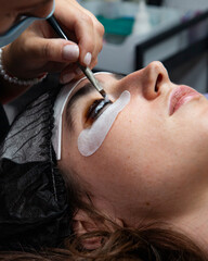 Close-up of a brush with eyelash dye during a cosmetic procedure. A cosmetologist applies a...