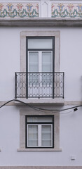 Elegant balcony on a white building with decorative details in an urban setting during daylight hours