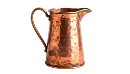 A hammered copper pitcher stands against a stark black backdrop, exuding rustic charm and reflecting subtle lighting
