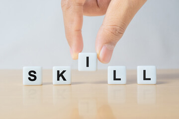 Businessman Arranging Dice to Form Skill Word