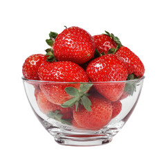 Strawberries fill a glass bowl, vividly red against a stark, black background