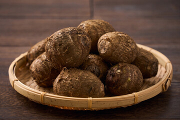 里芋（泥付き）を竹籠に盛った和風の食材カット