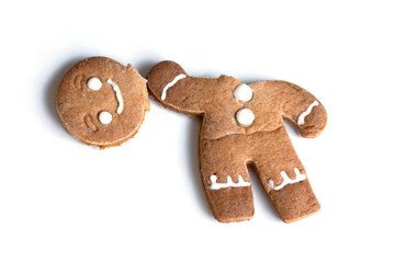 Broken gingerbread man cookie on white background. Concept of holiday humor, imperfection, or playful Christmas mishap. Funny festive composition for creative design or greeting cards