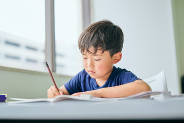 ノートに書き取りをする小学生の男の子