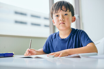 ノートに書き取りをする小学生の男の子