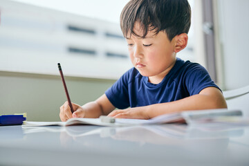 ノートに書き取りをする小学生の男の子