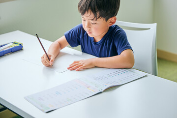 ノートに書き取りをする小学生の男の子