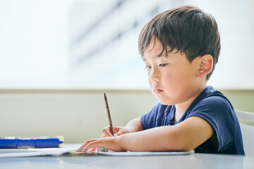 ノートに書き取りをする小学生の男の子