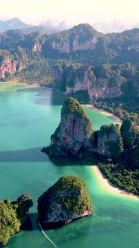 Breathtaking landscape overlooking the limestone cliffs and vibrant turquoise waters of Krabi Thailands coastline. Calm waves lap against the beach, Railay Beach, Krab,i Thailand