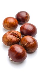Fototapeta premium Close-up of several smooth, brown nuts scattered on a white surface